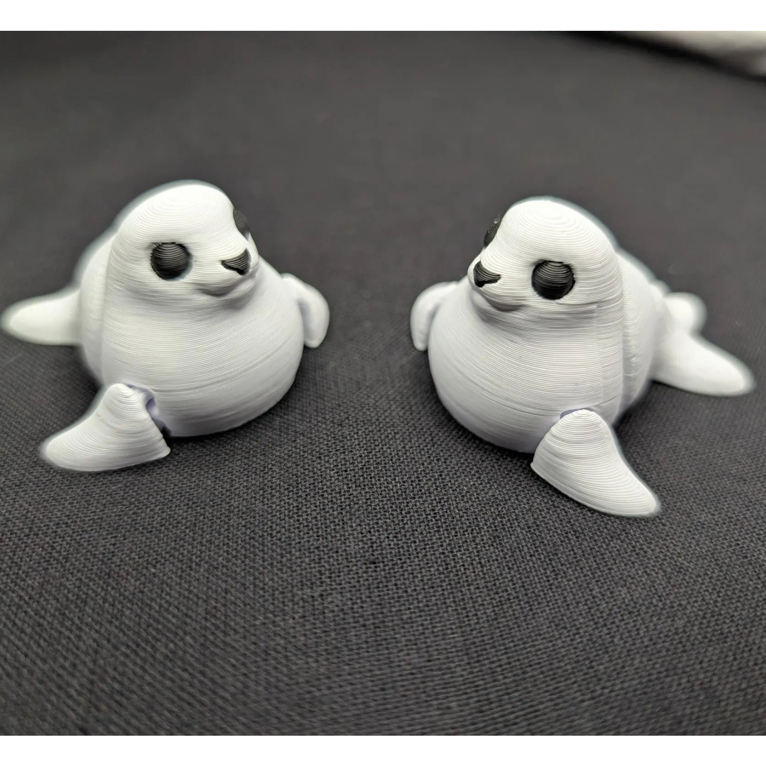 Two 3D-printed seal figurines on a gray surface