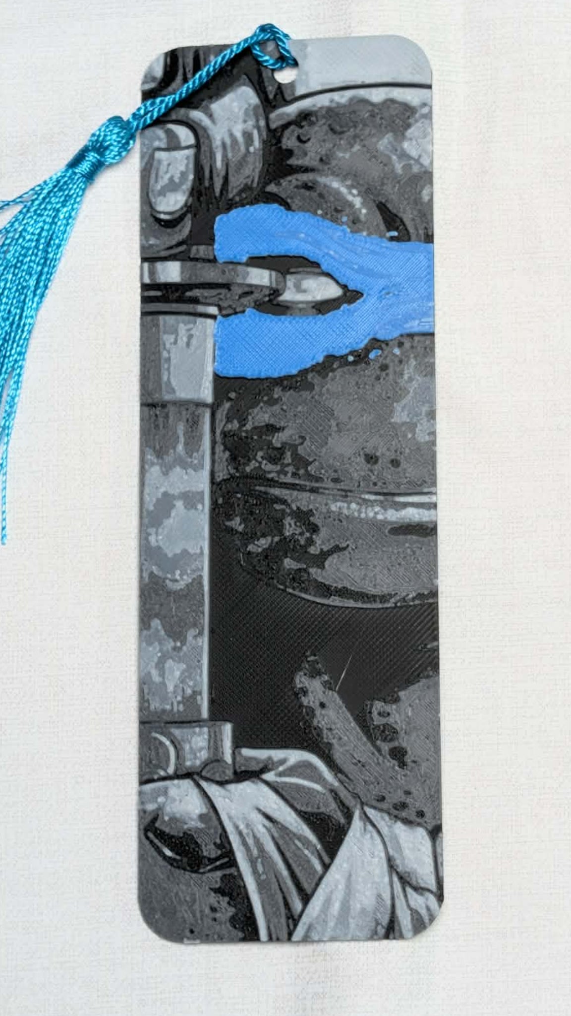 Bookmark with tassel featuring a black and white design on a white background
