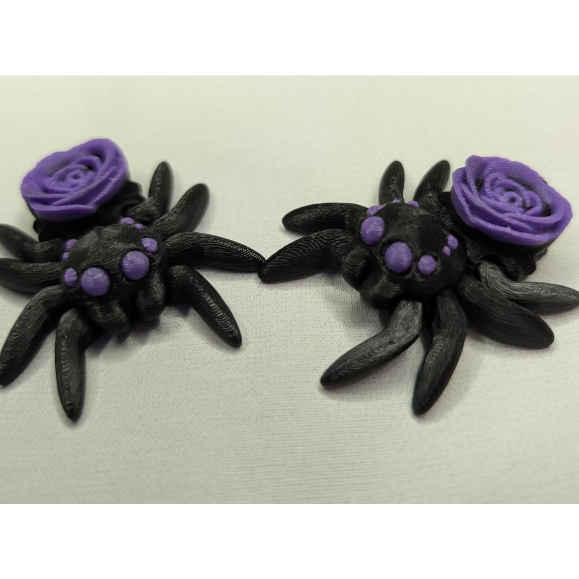 Black spider with purple roses on a beige background