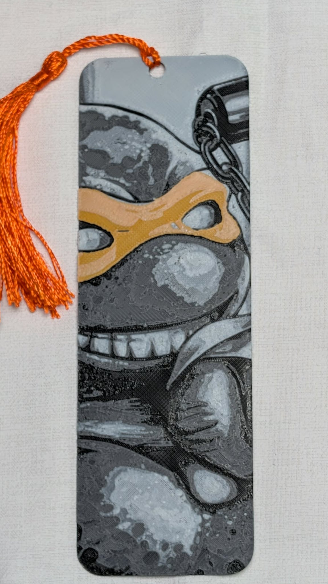 Bookmark with a stylized face design on a textured surface