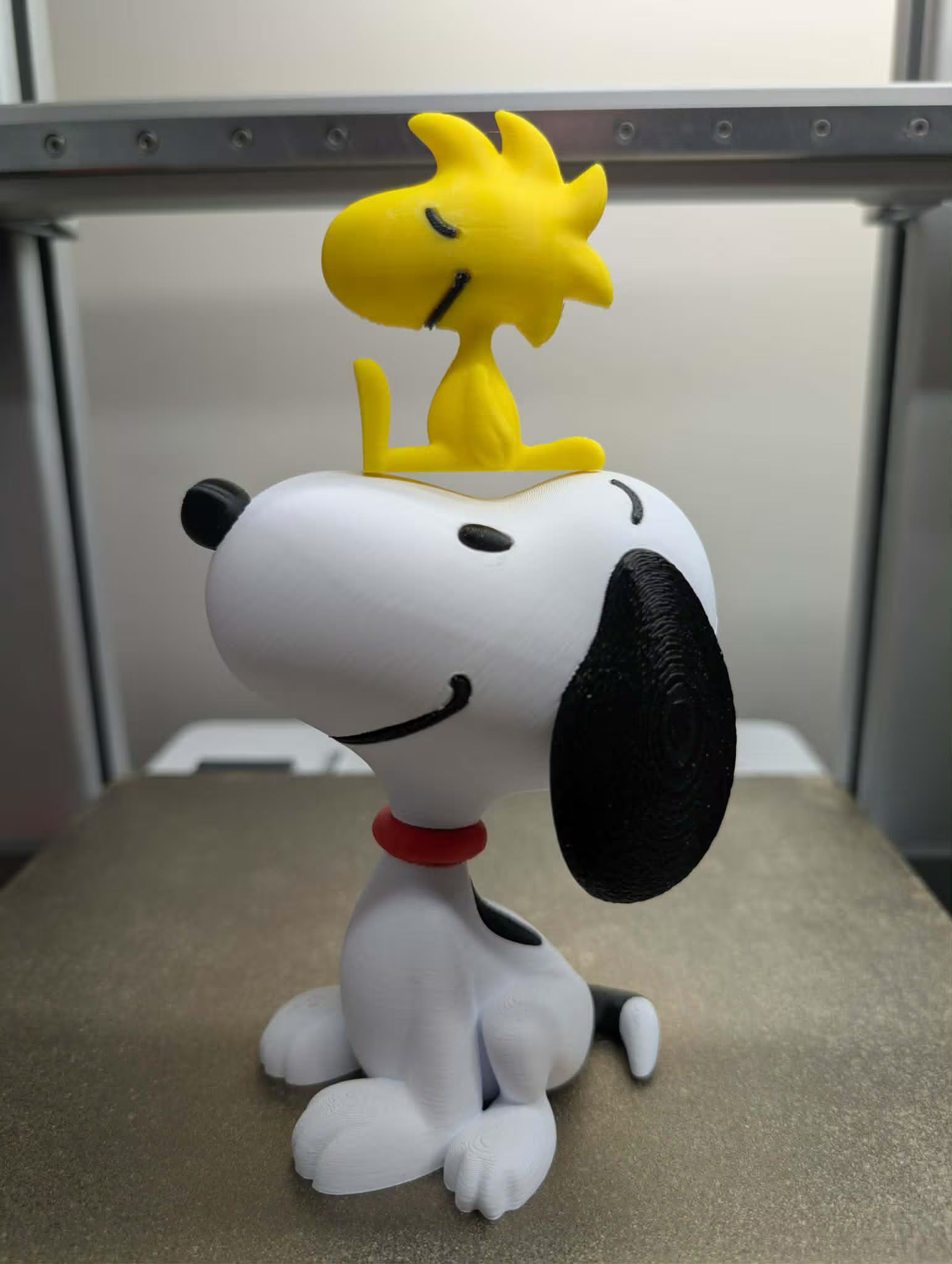 Snoopy and Woodstock figurine on a flat surface with a neutral background