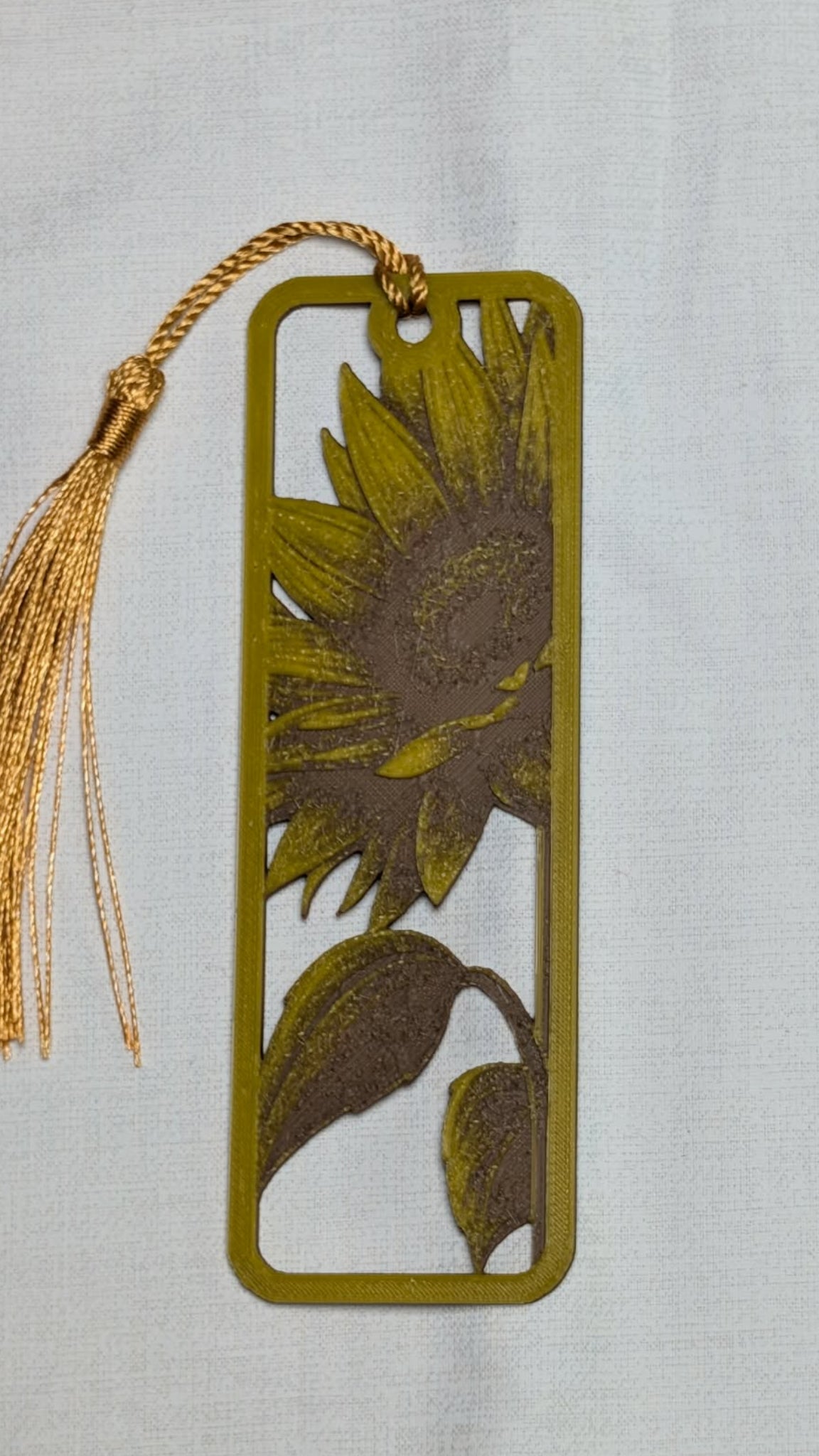 Sunflower design bookmark with tassel on a light gray background