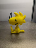 Yellow cartoon character figurine on a gray surface