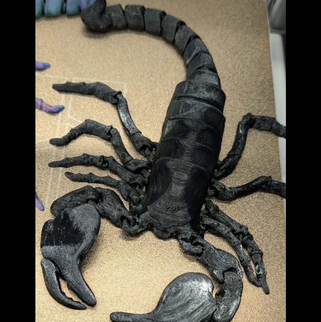 Black scorpion model on a beige surface