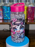 Glittery water bottle with cartoon character design on a blue stand, colorful jars in the background.