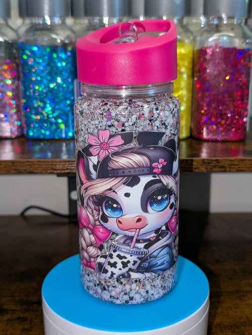 Glittery water bottle with cartoon character design on a blue stand, colorful jars in the background.