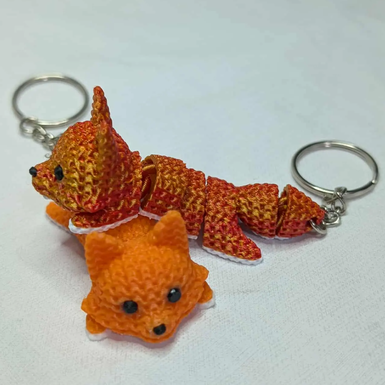 Two fox-shaped keychains on a white background