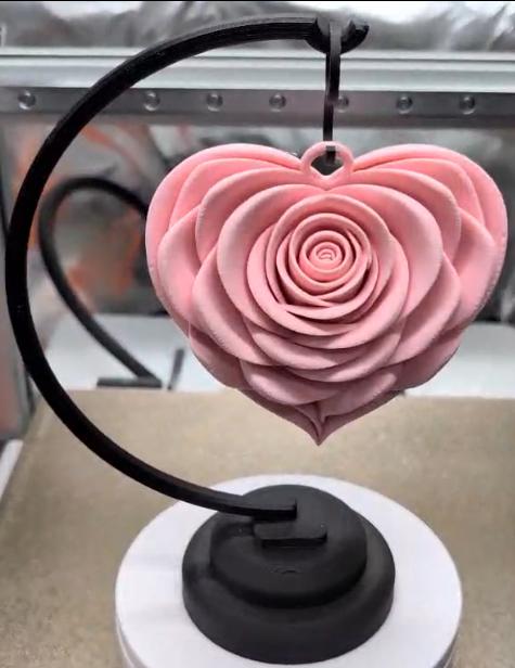 Pink heart-shaped object on a black stand with a blurred background