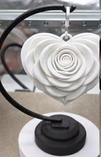 White heart-shaped object on a black stand with a blurred background