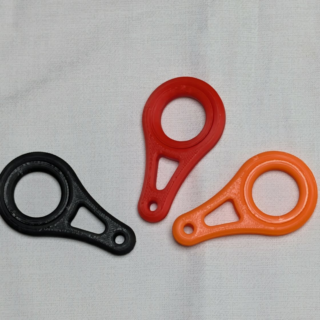 Three round objects in black, red, and orange on a light gray background