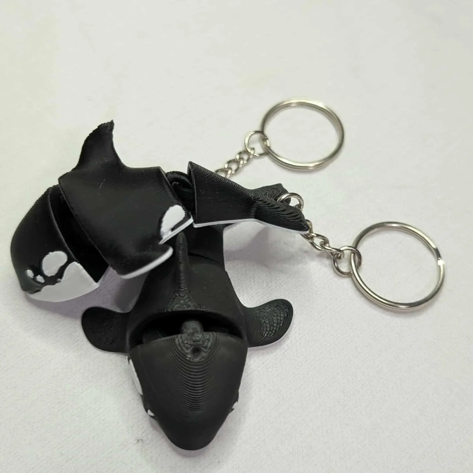 Black orca-shaped keychain on a white background