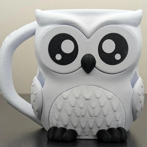 White owl-shaped mug with black accents on a neutral background