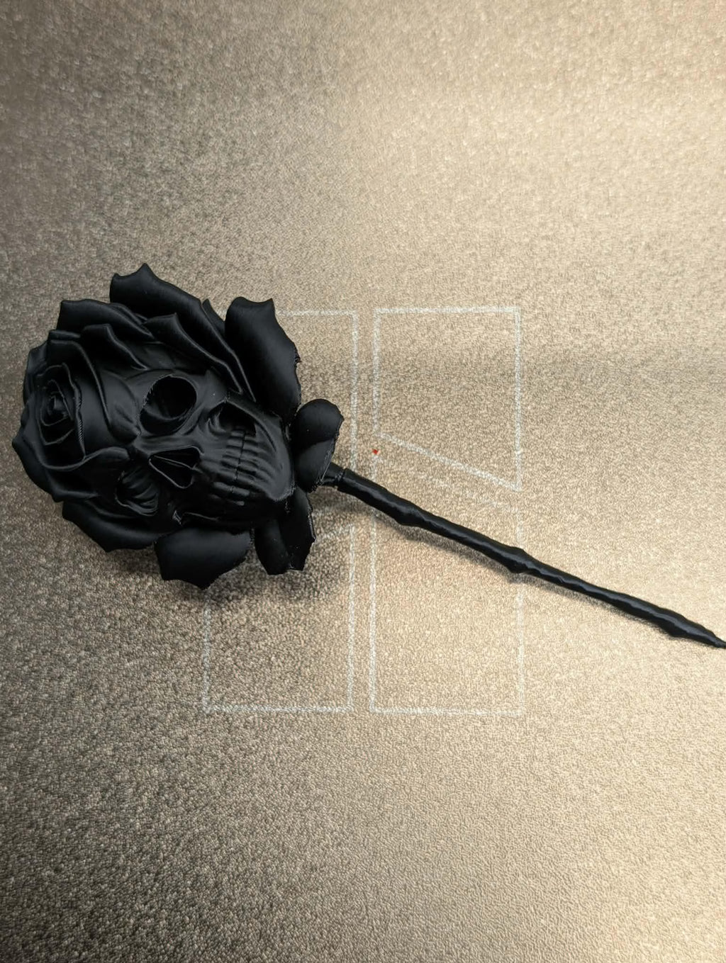 Black rose on a textured beige surface