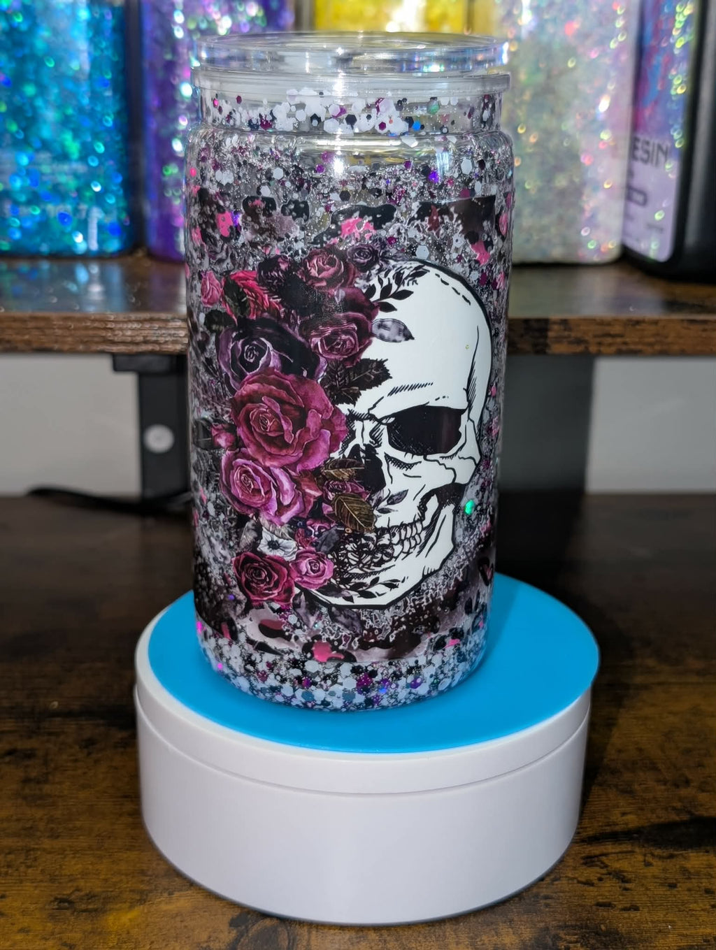 Tumbler with skull and floral design on a wooden surface